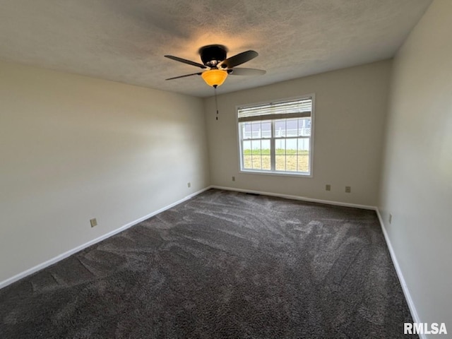 empty room with dark carpet, baseboards, a ceiling fan, and a textured ceiling