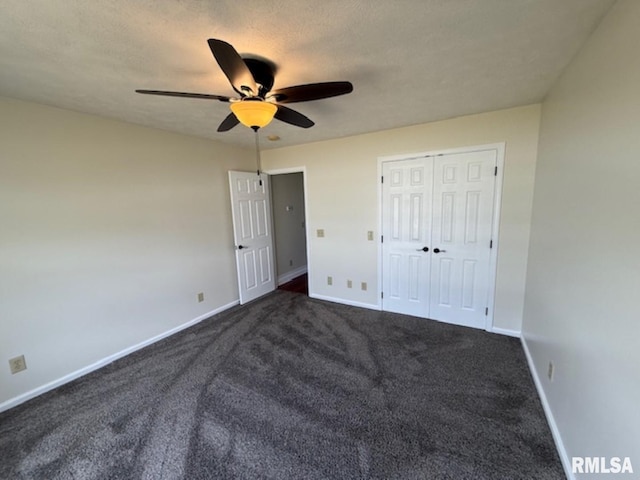 unfurnished bedroom with a closet, baseboards, dark carpet, and ceiling fan
