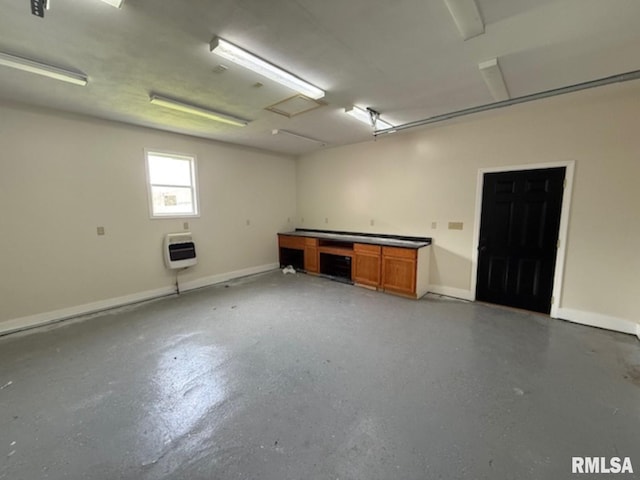 garage with baseboards and heating unit