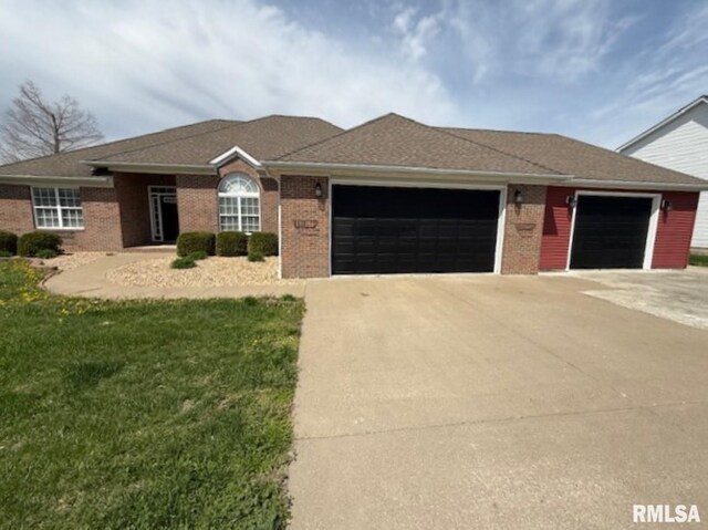 ranch-style home featuring a garage, a front yard, driveway, and brick siding