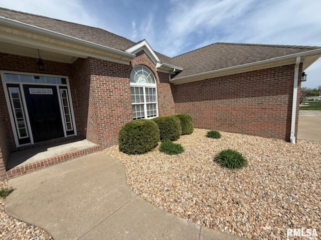 property entrance featuring brick siding