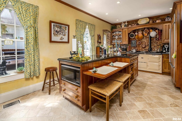 bar with stainless steel microwave, plenty of natural light, visible vents, and stone tile floors