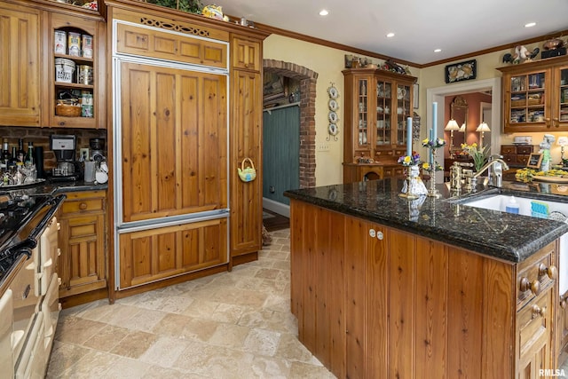 kitchen featuring recessed lighting, ornamental molding, brown cabinetry, and stone tile flooring