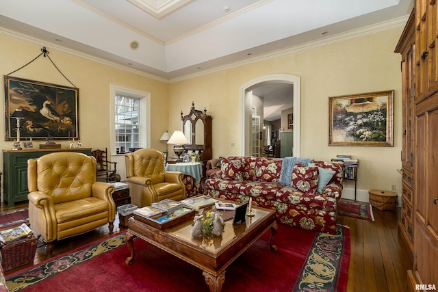 living room featuring arched walkways, a tray ceiling, hardwood / wood-style flooring, and ornamental molding