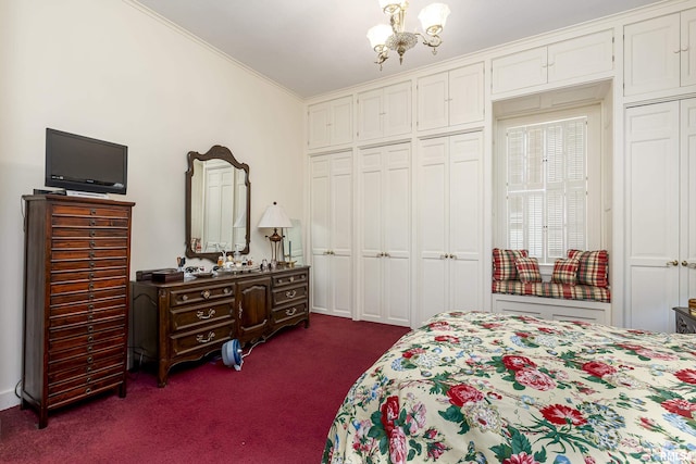 bedroom with an inviting chandelier, dark colored carpet, ornamental molding, and multiple closets