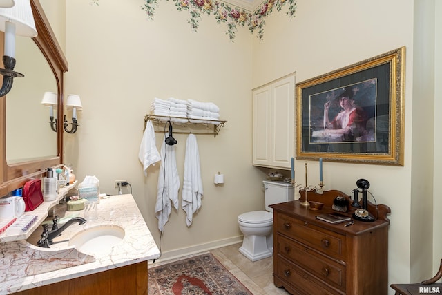 bathroom with toilet, tile patterned floors, baseboards, and vanity