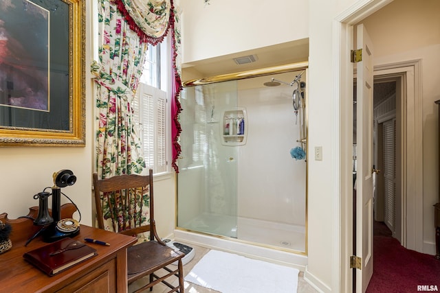 bathroom with a stall shower and visible vents