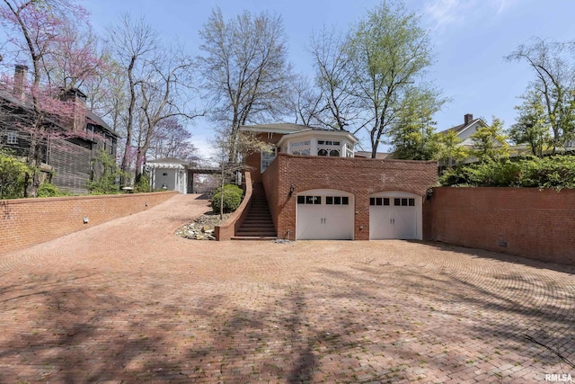 exterior space featuring decorative driveway and stairway