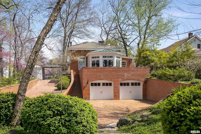 garage featuring driveway and fence