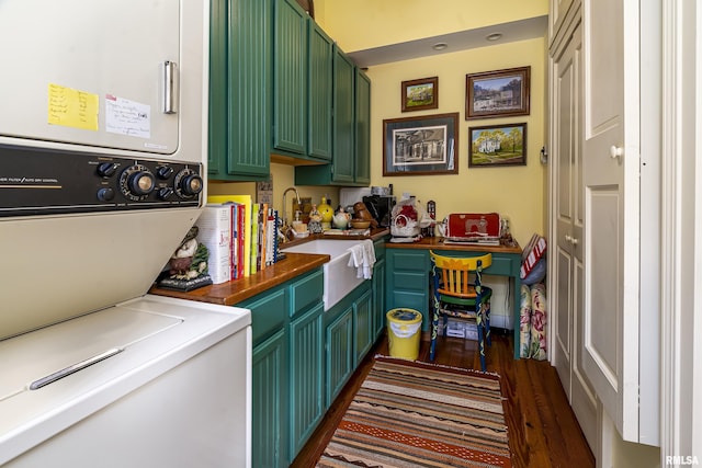 laundry area featuring stacked washer and dryer, a sink, and dark wood finished floors