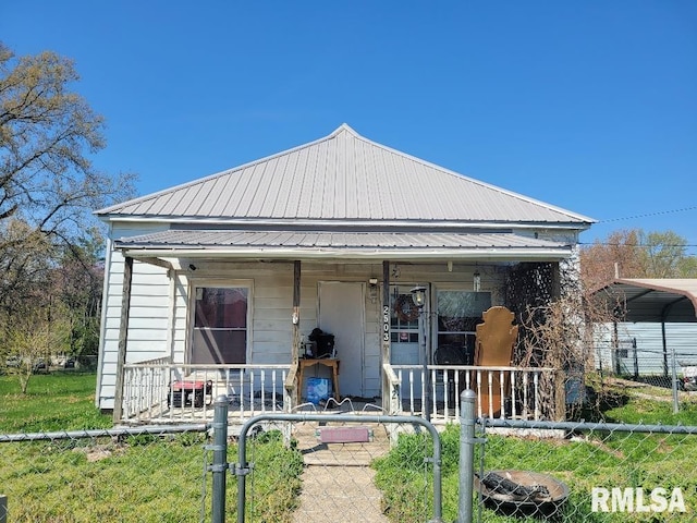 view of front of house with a gate, a porch, metal roof, and a fenced front yard