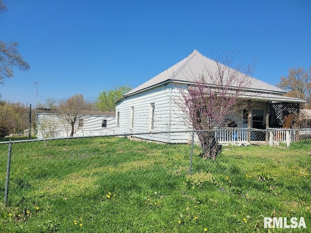 view of side of home featuring fence and a lawn