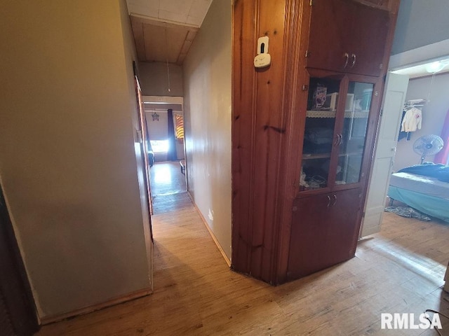 hallway featuring light wood finished floors and attic access