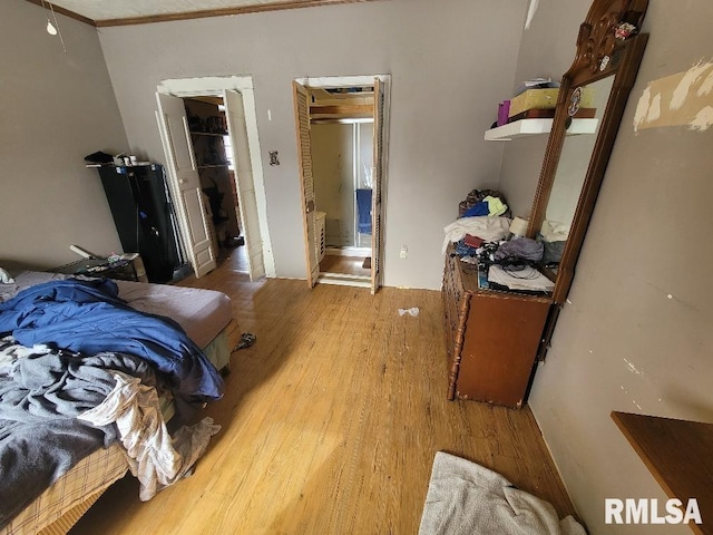 bedroom with crown molding and wood finished floors