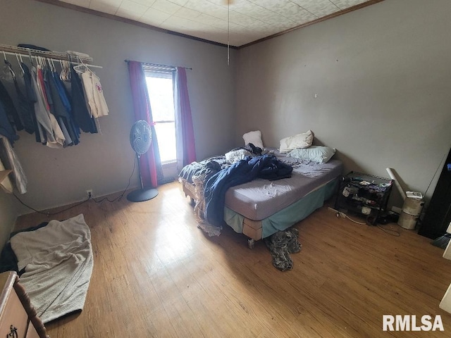 bedroom featuring crown molding and wood finished floors