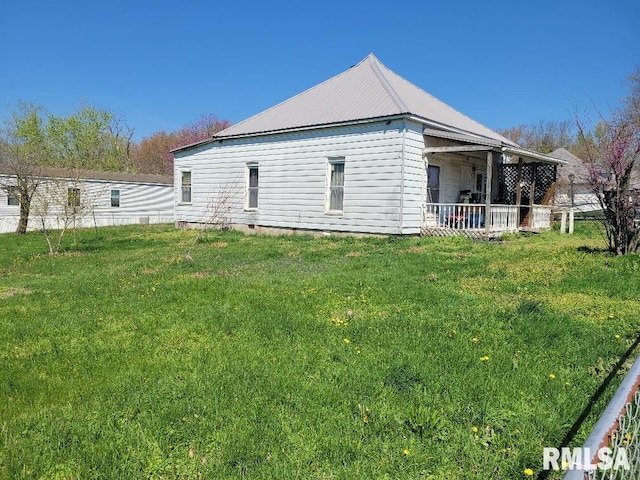 view of home's exterior with metal roof and a lawn
