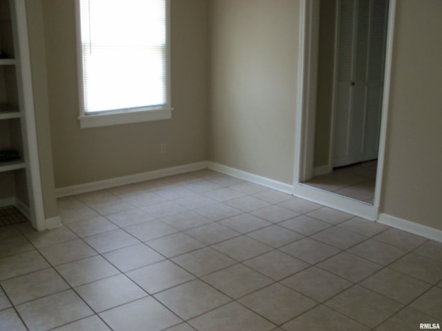 1003 S Johnson Ave, Carbondale, IL 62901 - unfurnished bedroom featuring a closet, baseboards, and light tile patterned floors
