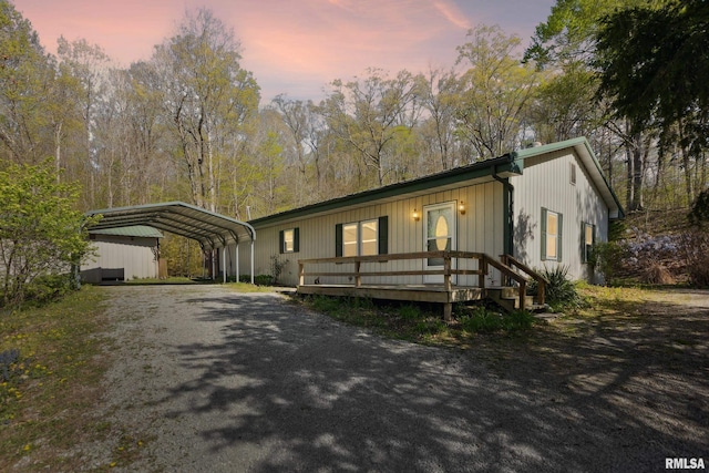 view of front of property with gravel driveway and a detached carport