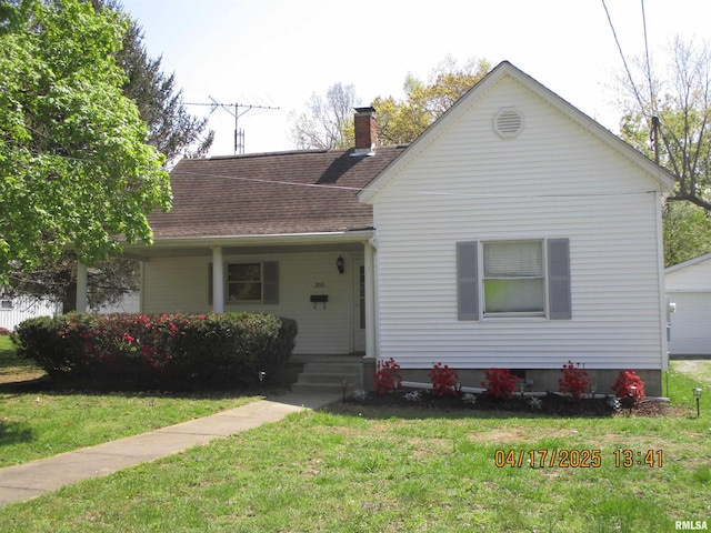 205 Texas St, Carterville, IL 62918 - view of front of home with a chimney, a front lawn, roof with shingles, and a porch