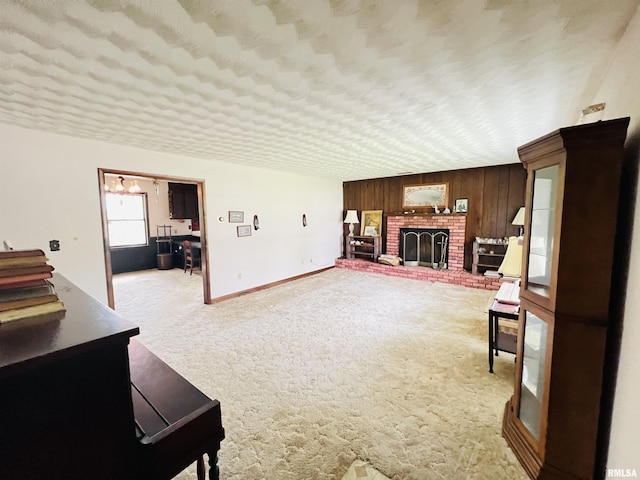 living room with light carpet, a textured ceiling, baseboards, wood walls, and a fireplace