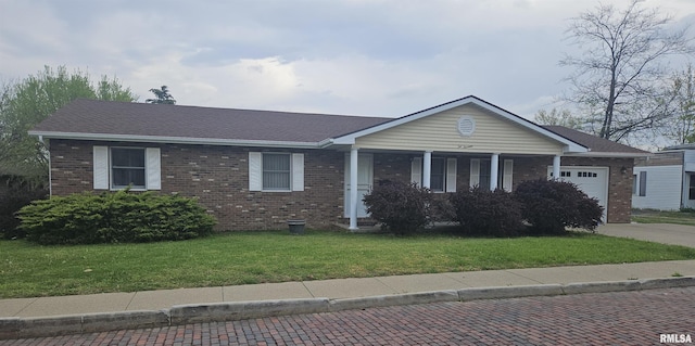 214 W Locust St, Harrisburg, IL 62946 - single story home featuring a front lawn, concrete driveway, covered porch, a garage, and brick siding