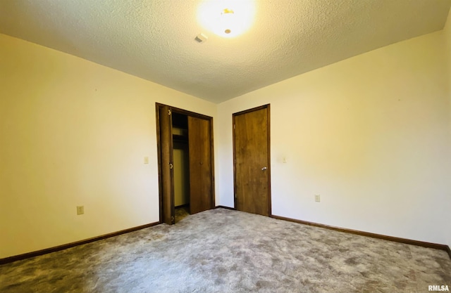 214 W Locust St, Harrisburg, IL 62946 - unfurnished bedroom featuring baseboards, carpet, and a textured ceiling