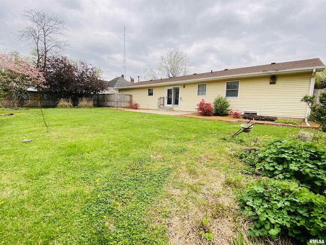 214 W Locust St, Harrisburg, IL 62946 - rear view of property featuring a fenced backyard, a patio area, and a lawn