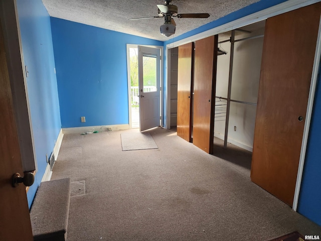 unfurnished bedroom featuring a ceiling fan, a closet, baseboards, a textured ceiling, and carpet flooring