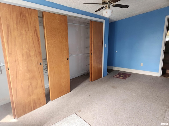 unfurnished bedroom featuring a textured ceiling, baseboards, carpet, a closet, and ceiling fan