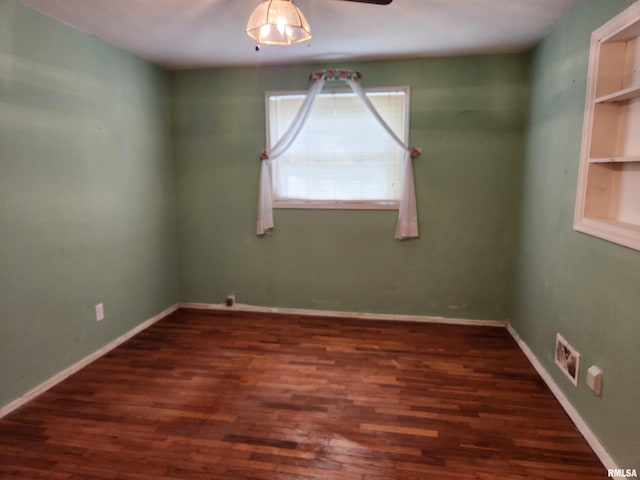 spare room featuring visible vents, baseboards, wood finished floors, and ceiling fan