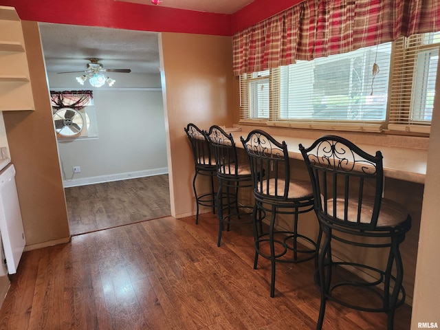 dining space featuring baseboards, a ceiling fan, and wood finished floors