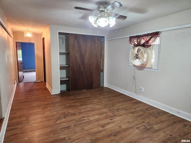 unfurnished bedroom with ceiling fan, baseboards, wood finished floors, and a textured ceiling