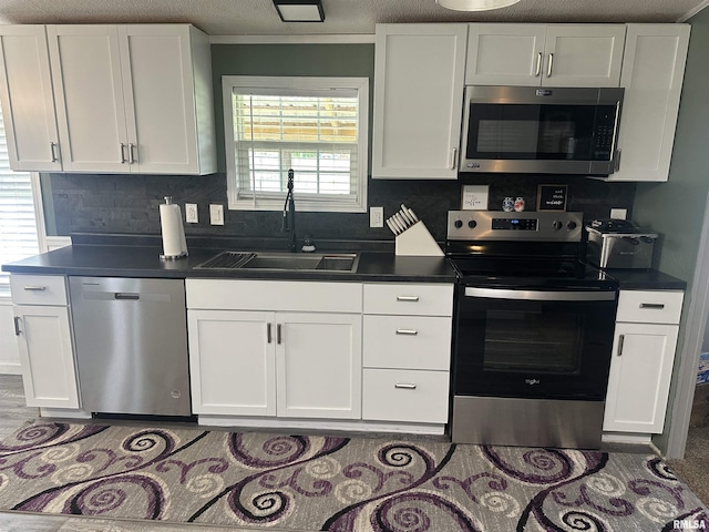 15 Lincoln St, Stonefort, IL 62987 - kitchen with stainless steel appliances, a sink, white cabinetry, and dark countertops