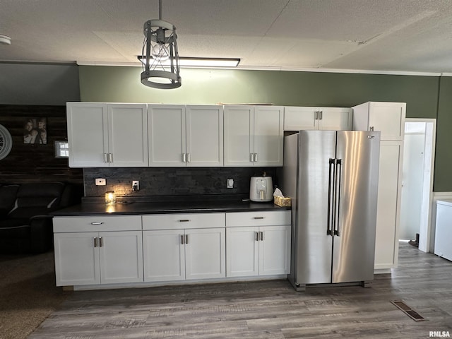 15 Lincoln St, Stonefort, IL 62987 - kitchen with visible vents, dark countertops, freestanding refrigerator, and white cabinetry