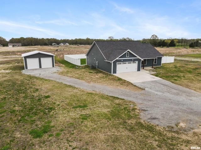 view of front of home featuring a front lawn, fence, an outbuilding, and a shingled roof