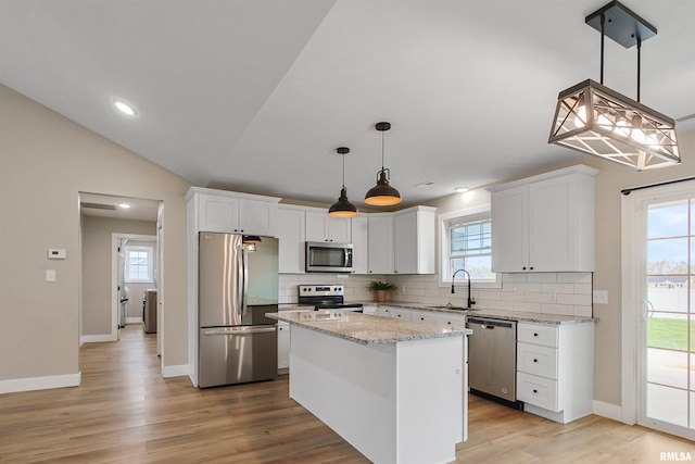 kitchen with white cabinets, backsplash, a healthy amount of sunlight, a sink, and appliances with stainless steel finishes