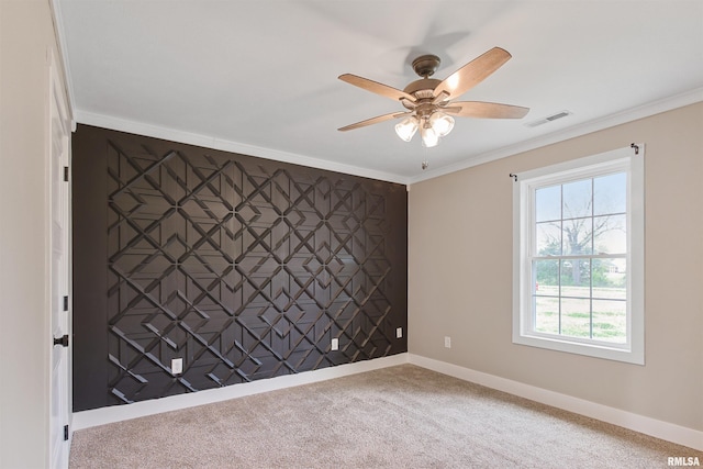 empty room featuring baseboards, visible vents, a ceiling fan, carpet floors, and ornamental molding