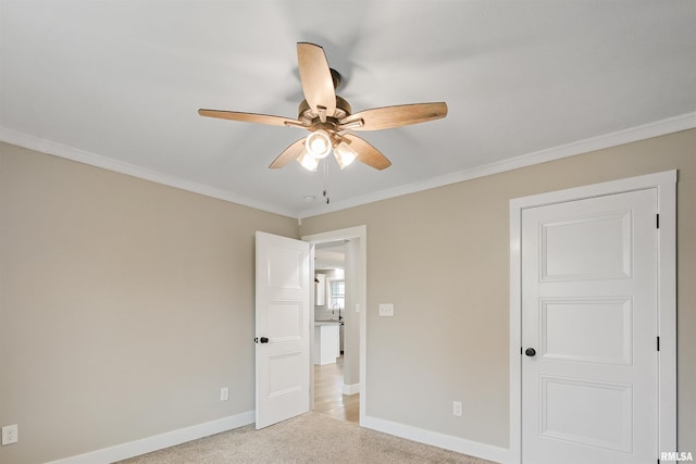 unfurnished bedroom with ceiling fan, baseboards, carpet, and ornamental molding