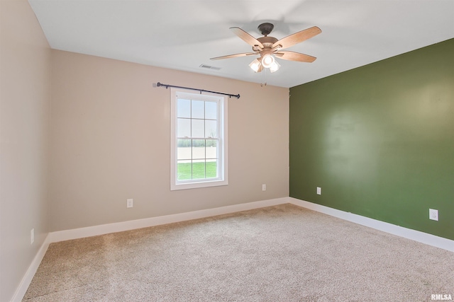 spare room with baseboards, a ceiling fan, carpet flooring, and visible vents