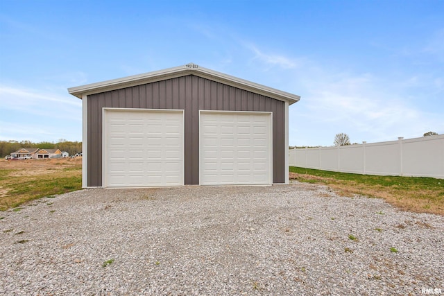 detached garage featuring fence