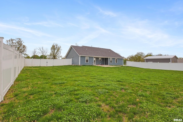 rear view of house with a lawn, a patio, and a fenced backyard