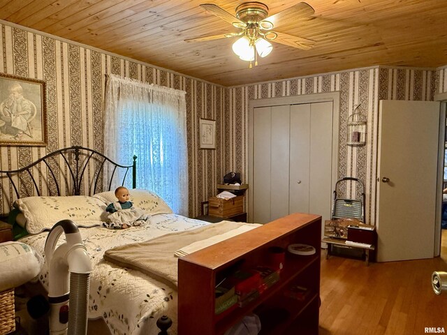 8806 Unionville Rd, Brookport, IL 62910 - bedroom featuring a closet, wood finished floors, ceiling fan, wallpapered walls, and wooden ceiling