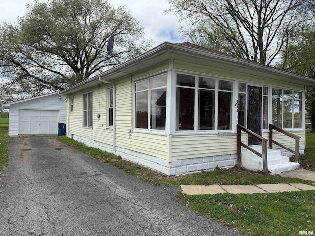 531 N Bush Ave, Hurst, IL 62949 - view of home's exterior with an outdoor structure, entry steps, a sunroom, and aphalt driveway