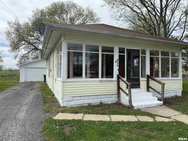 531 N Bush Ave, Hurst, IL 62949 - view of front of home featuring a garage, entry steps, a sunroom, and an outdoor structure
