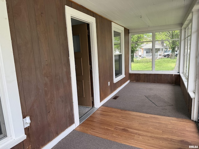 531 N Bush Ave, Hurst, IL 62949 - unfurnished sunroom featuring wood walls, visible vents, wood finished floors, and carpet floors