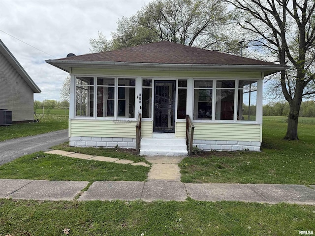 531 N Bush Ave, Hurst, IL 62949 - bungalow with a sunroom, a shingled roof, and a front lawn