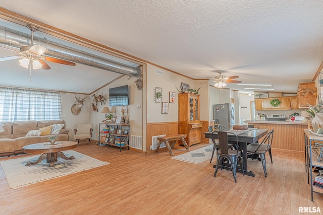 565 Dutton Chapel Rd, Golconda, IL 62938 - dining area featuring a ceiling fan, a textured ceiling, light wood-type flooring, a wainscoted wall, and visible vents