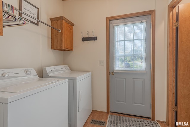 565 Dutton Chapel Rd, Golconda, IL 62938 - washroom featuring cabinet space, washer and clothes dryer, visible vents, and light wood-style floors