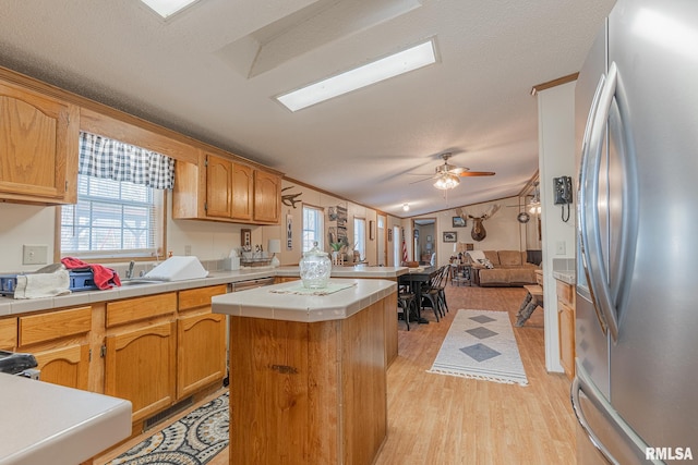 565 Dutton Chapel Rd, Golconda, IL 62938 - kitchen with lofted ceiling, light wood finished floors, a ceiling fan, freestanding refrigerator, and a center island