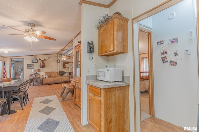 565 Dutton Chapel Rd, Golconda, IL 62938 - kitchen with light wood finished floors, white microwave, a textured ceiling, open floor plan, and ceiling fan